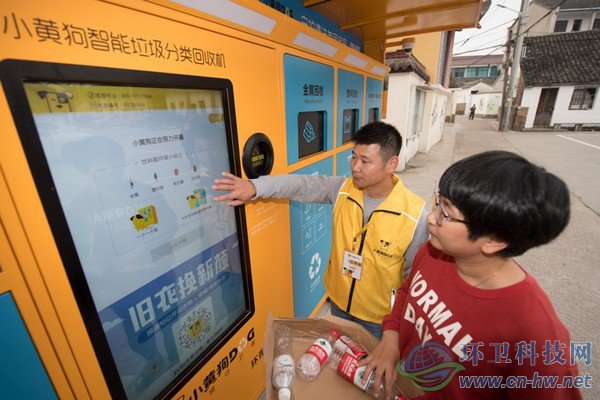 10月30日，在道場(chǎng)鄉(xiāng)錢山下村，工作人員（左）指導(dǎo)村民在智能回收機(jī)上進(jìn)行垃圾分類回收。